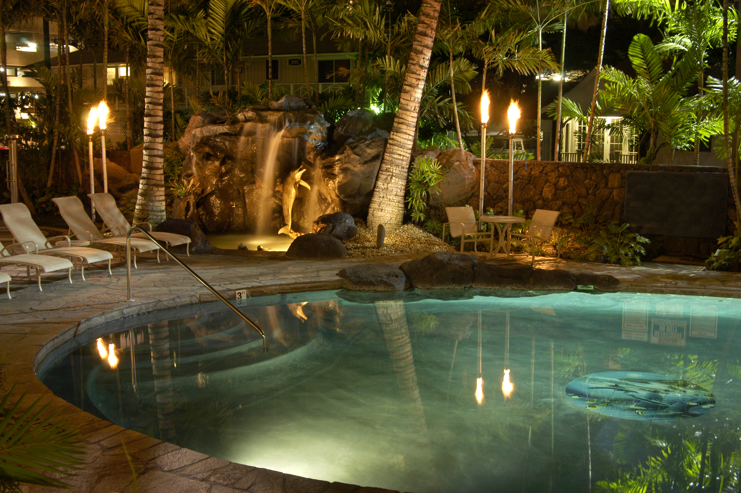 Tropical pool at night with torches